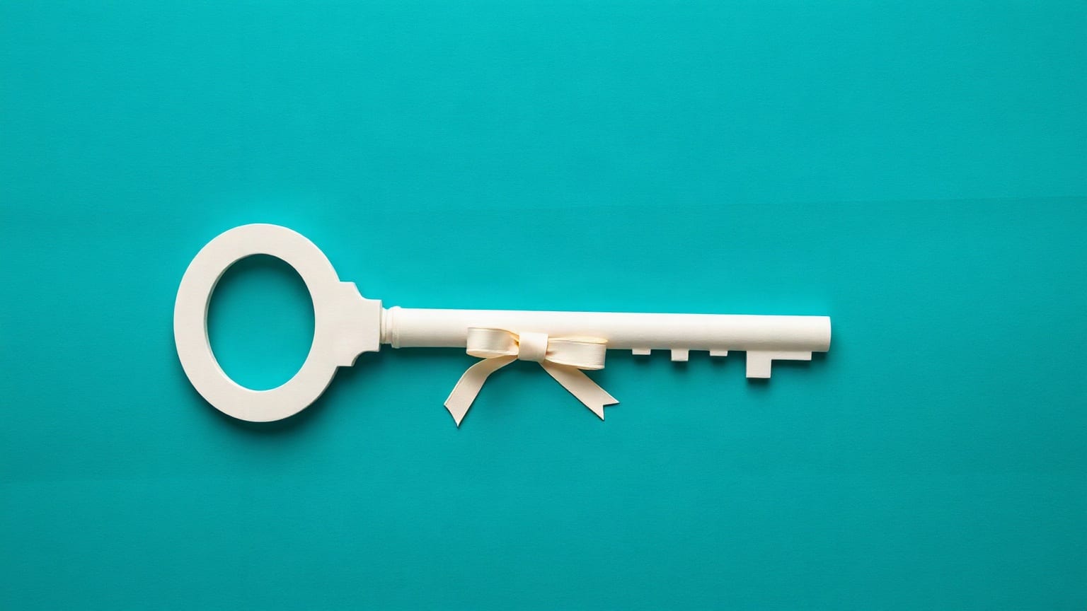 Cut-paper illustration: a key with a circular bow crossing the base of a tall tower.